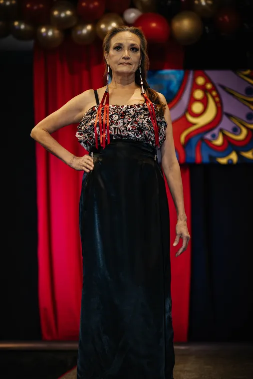 A woman models an Indigenous designed evening wear outfit.