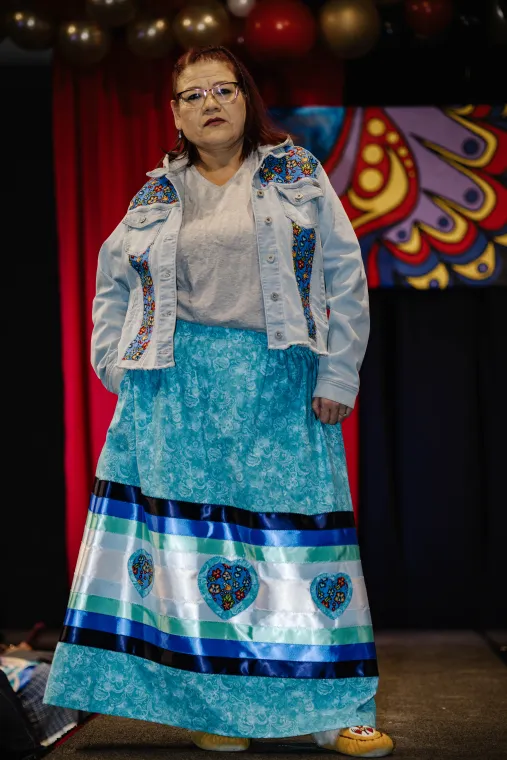 A woman models an Indigenous designed blue outfit.