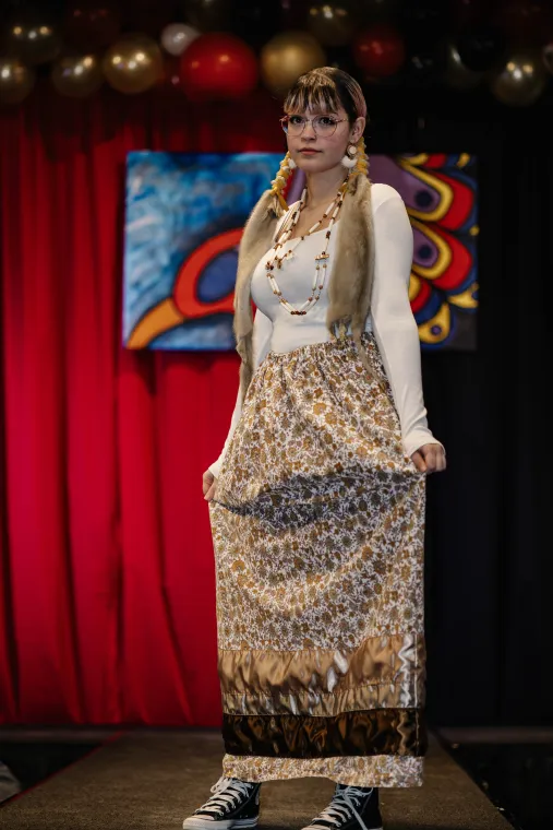 A young woman models an Indigenous designed outfit.