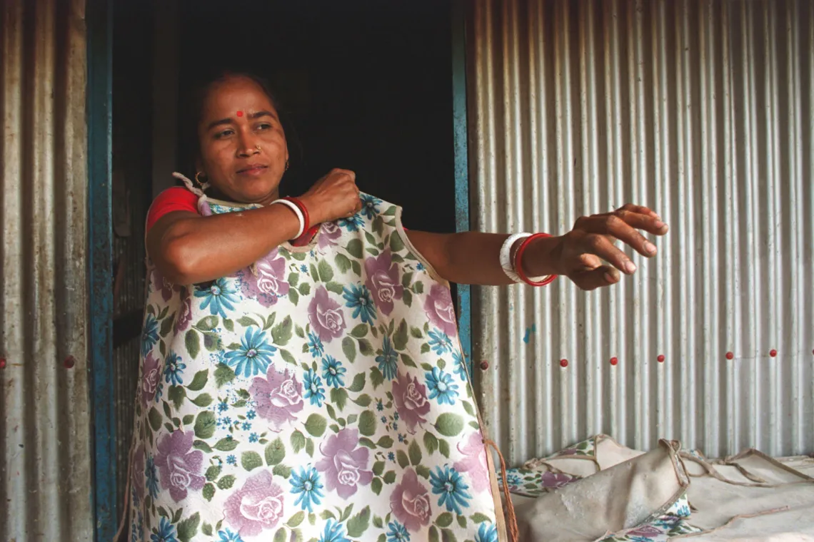 A woman puts on an apron decorated in a floral print.
