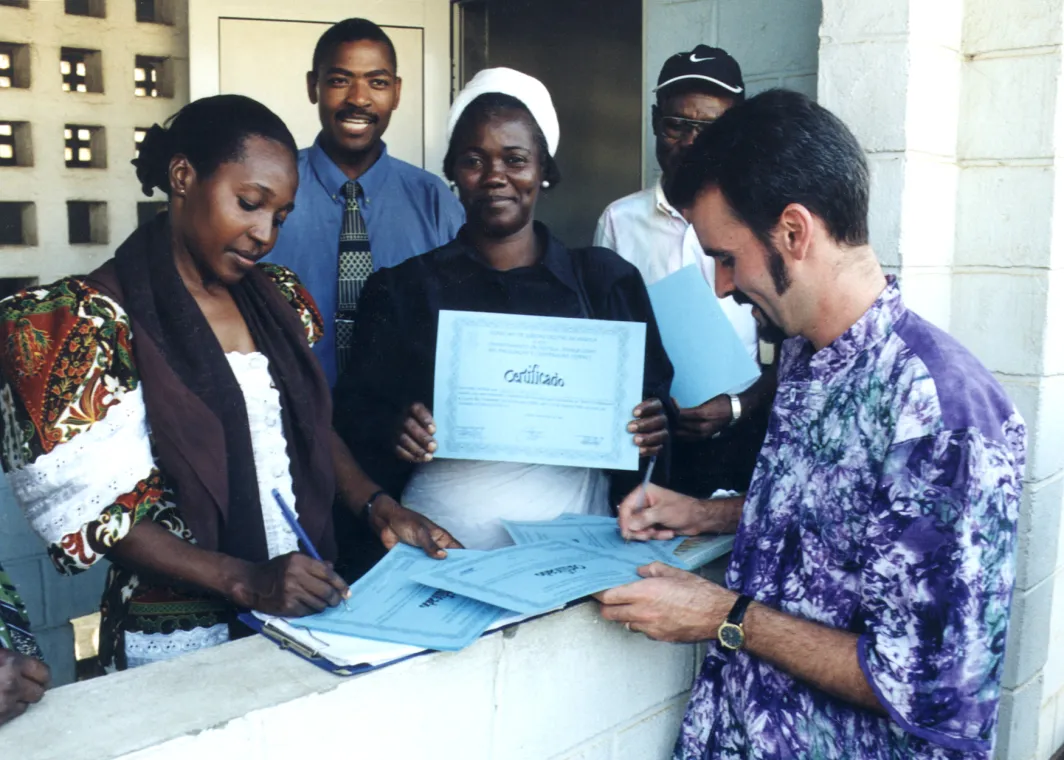 Man handing out certificates to a group of people.
