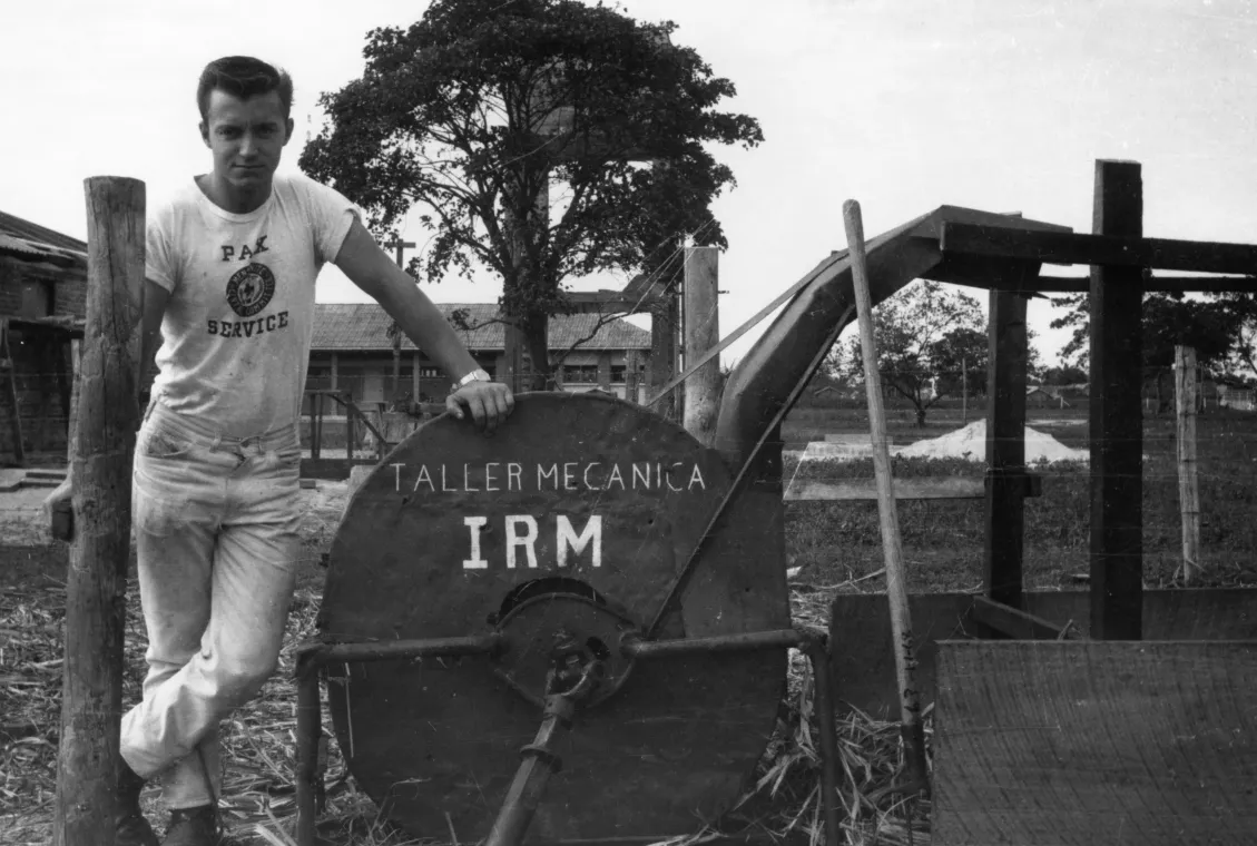 Man standing next to forage chopper.