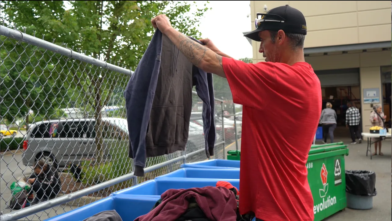 Rick selects clothing at the weekly barbecue hosted by MCC BC Homelessness Prevention and Outreach program