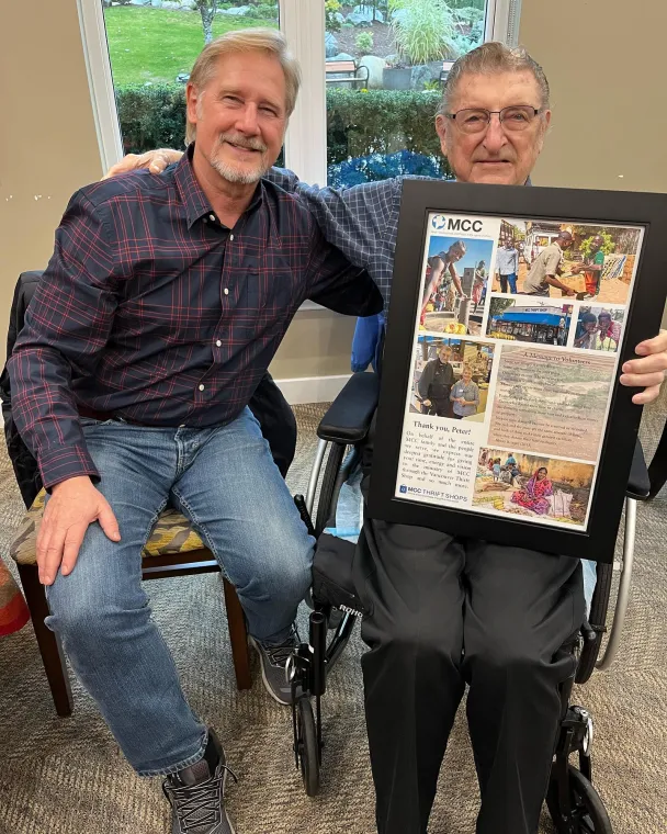 Wayne Bremner and Peter Funk holding a photo collage