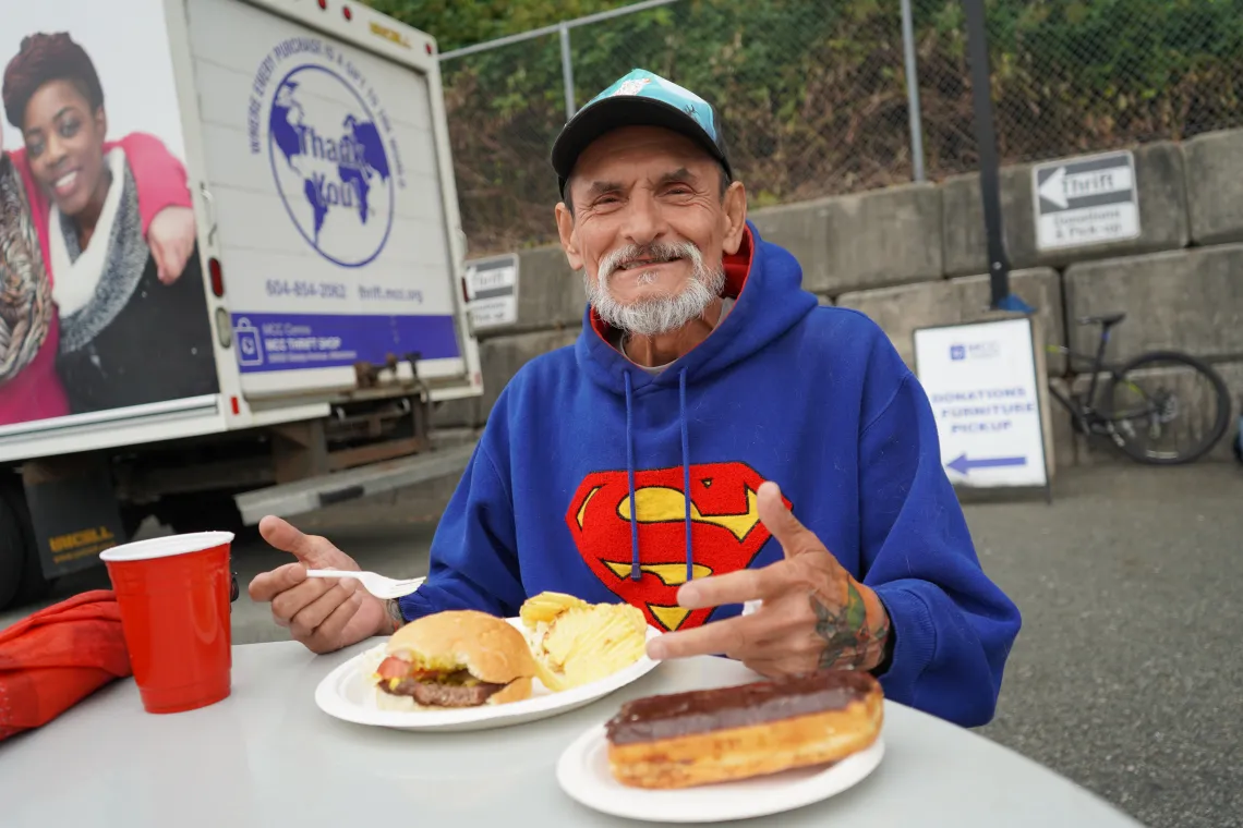 Randall Koski enjoys a burger and donut at the weekly barbecue hosted by the MCC BC Homelessness Prevention and Outreach program