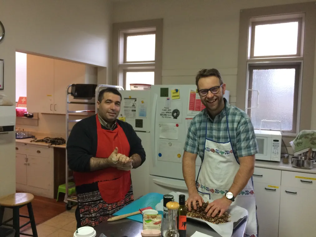 Two men preparing food in a kitchen