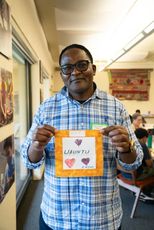 Man holding a fabric square that says Ubuntu.