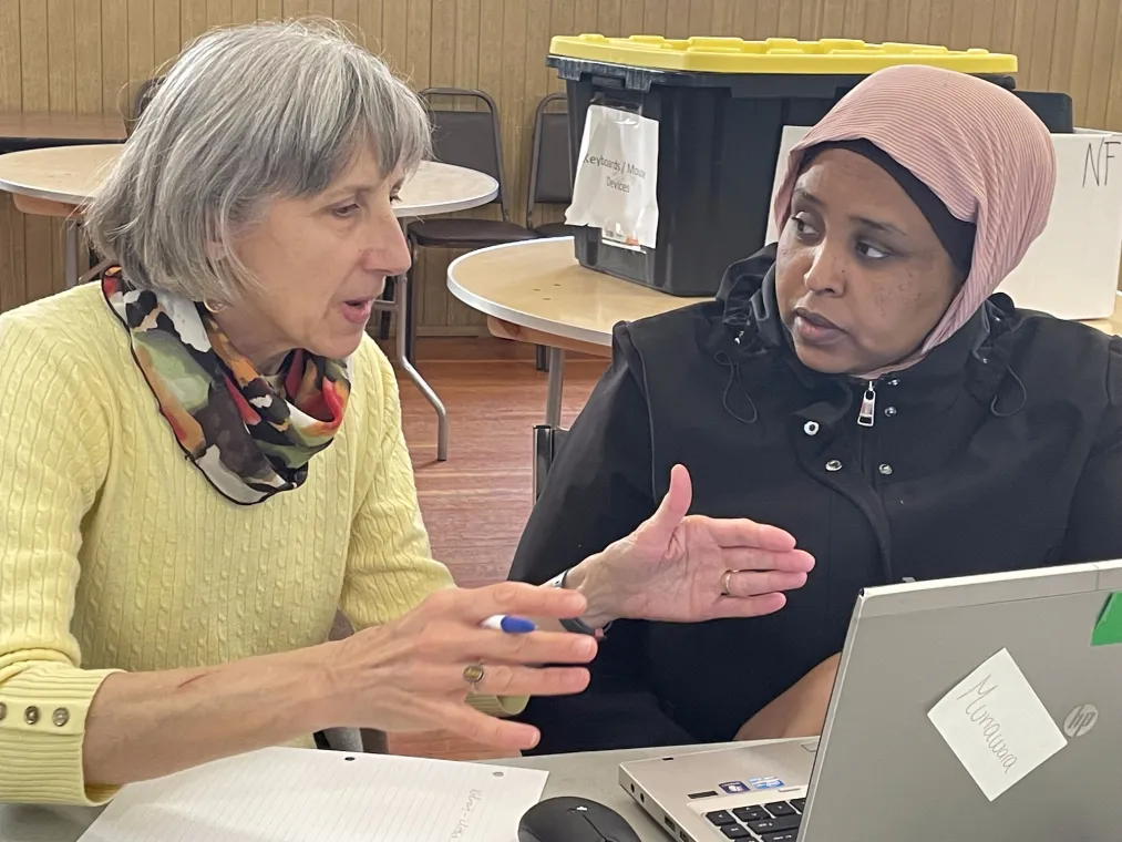 A volunteer explaining a topic to a program participant