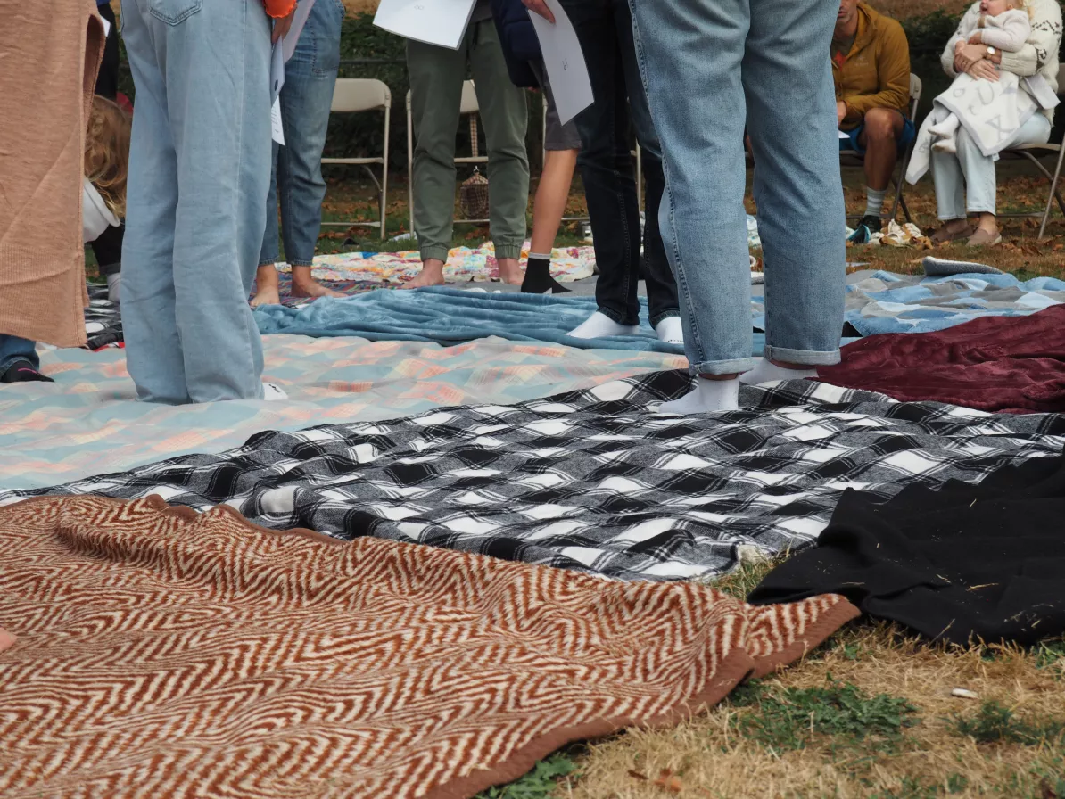 People stand on blankets without shoes on