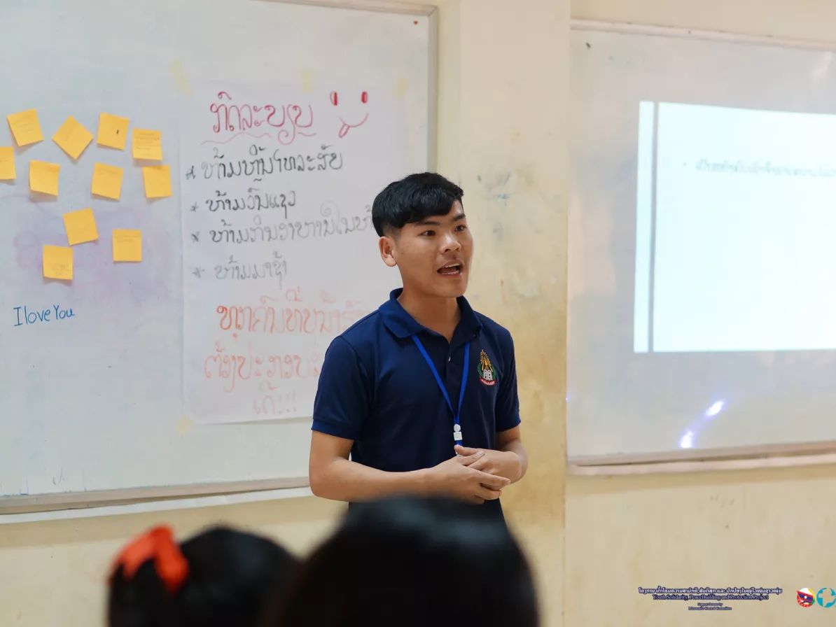 A man speaking in front of a classroom