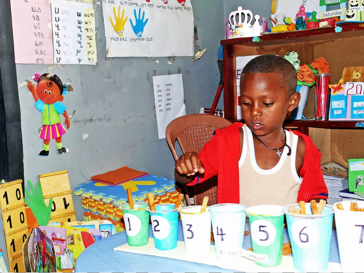 A student doing a counting activity in a classroom