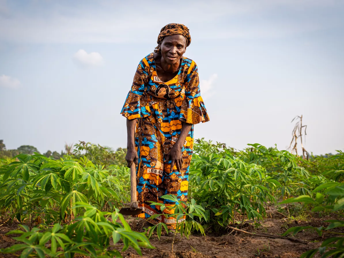 Marie Jeanne Kudimuka, 65 years old, mother of 10 adult children and two orphaned grandchildren, holds a hoe in the fields of Kanzombi.