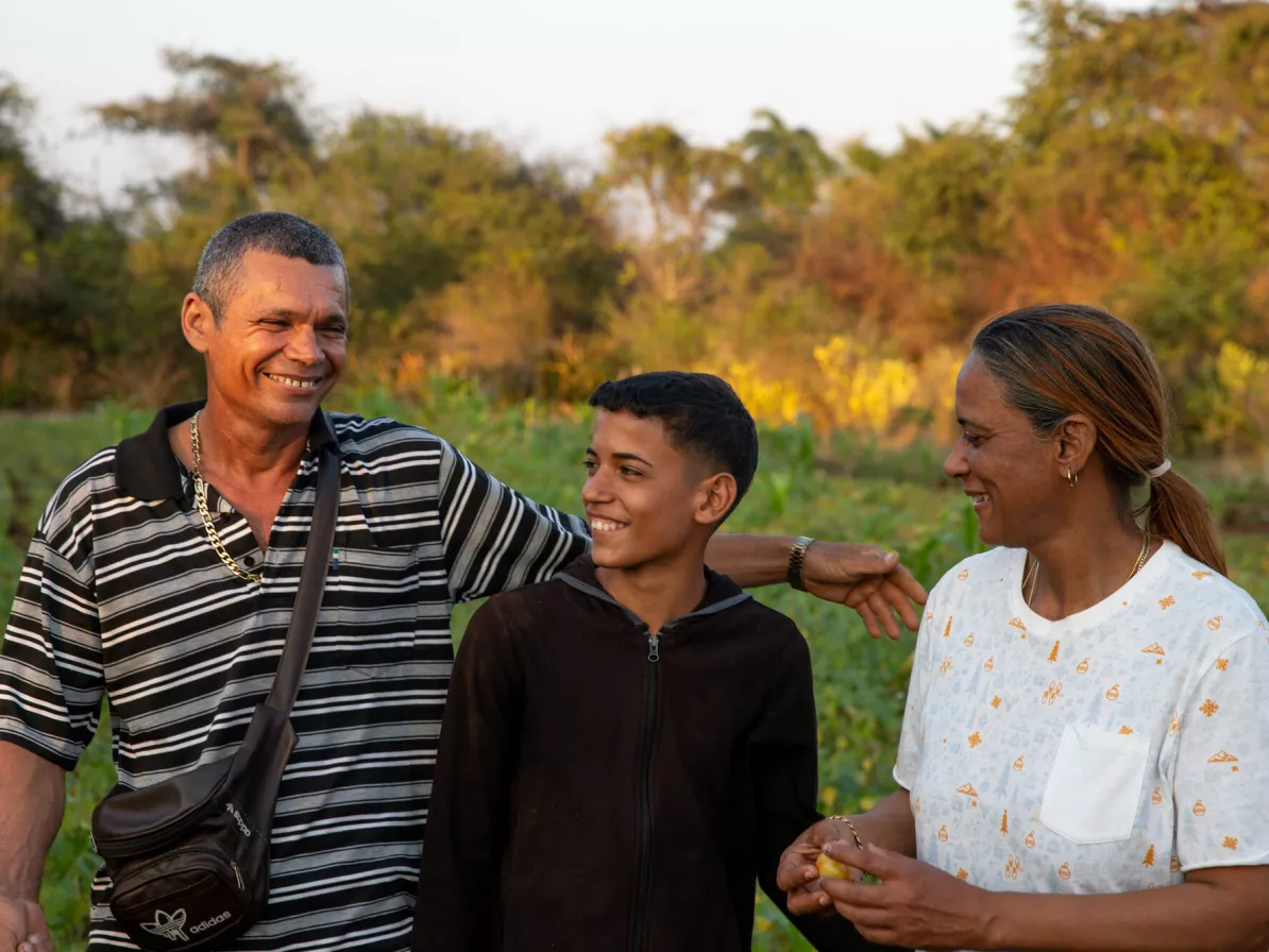 A man, boy and woman stand together in a field in Cuba