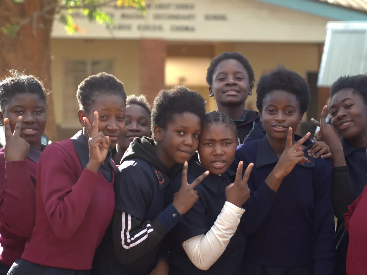 A group of students displaying the peace sign with their fingers