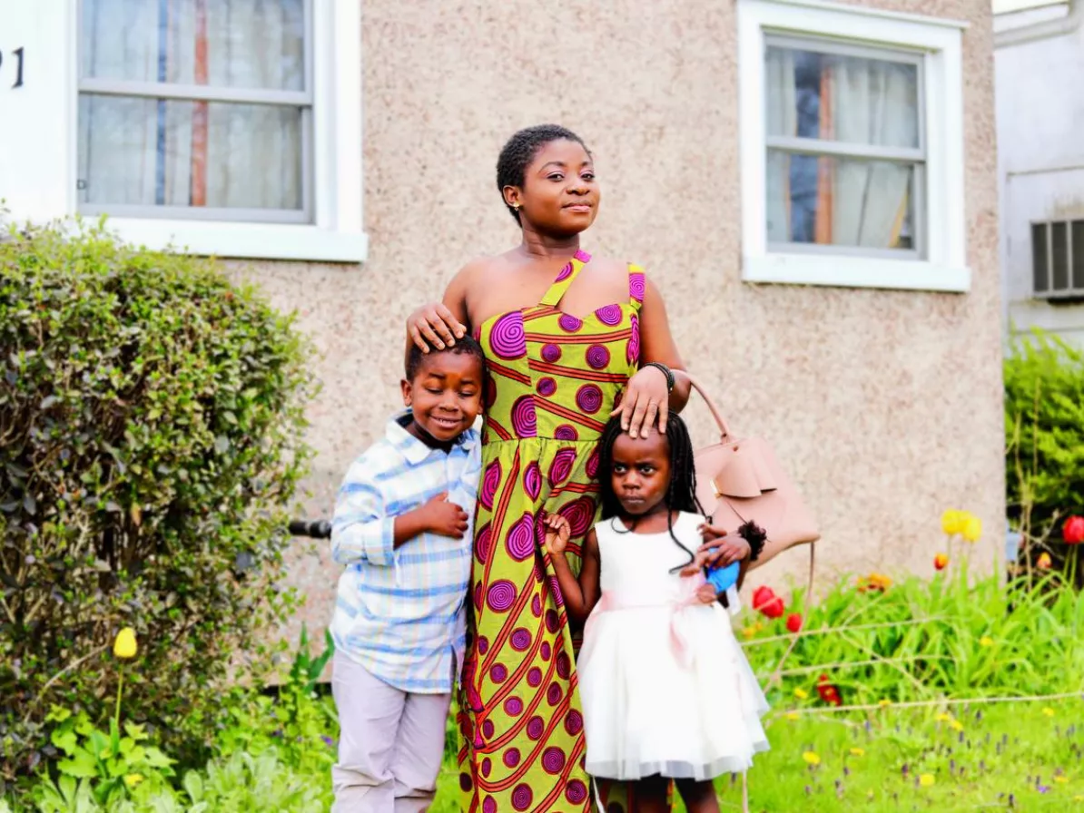 A woman standing with two children