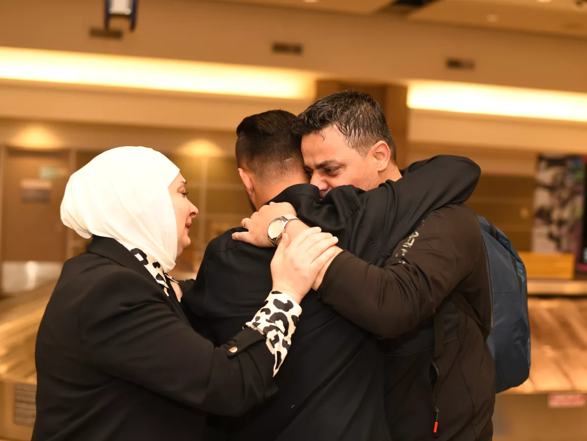 A family hugging at an airport