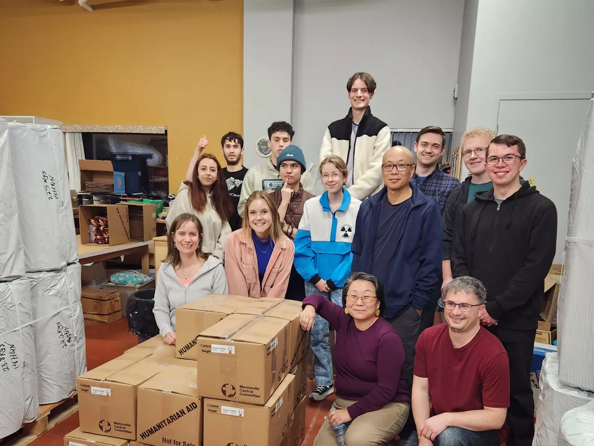 A group of volunteers standing with a pile of material resources