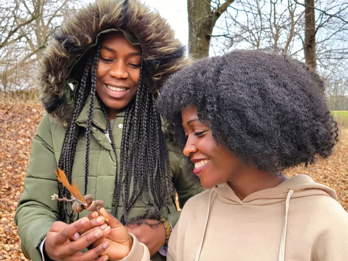 Josephine Kalondji, left, and Mwajuma Katembo admire an oak leaf while on a nature walk at Freedom Farm.