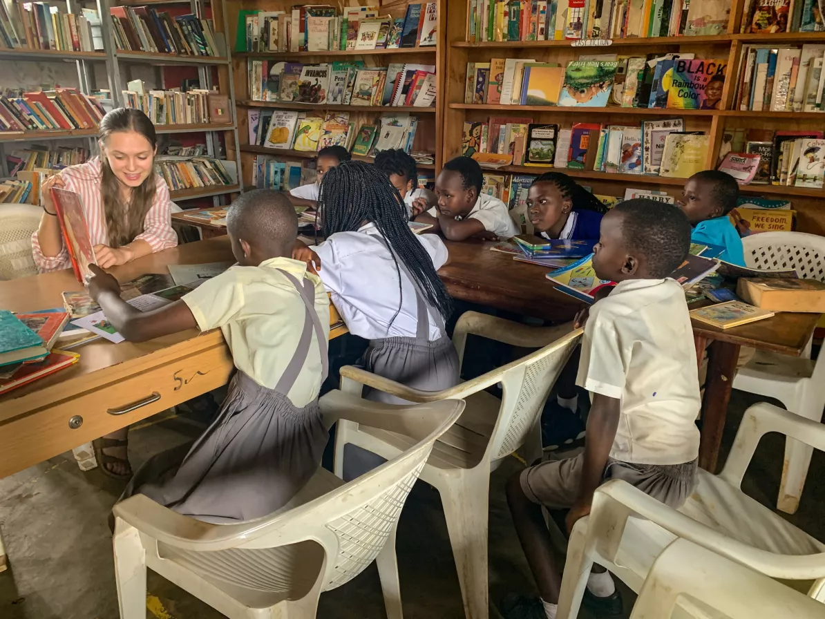 A young woman reading to a group of students