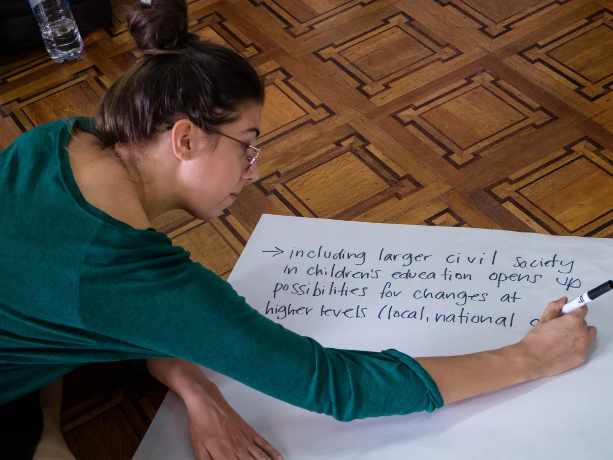 A young woman writing on a large piece of paper