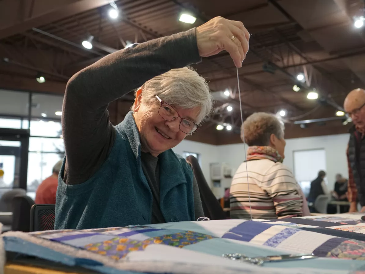 A woman sewing a comforter