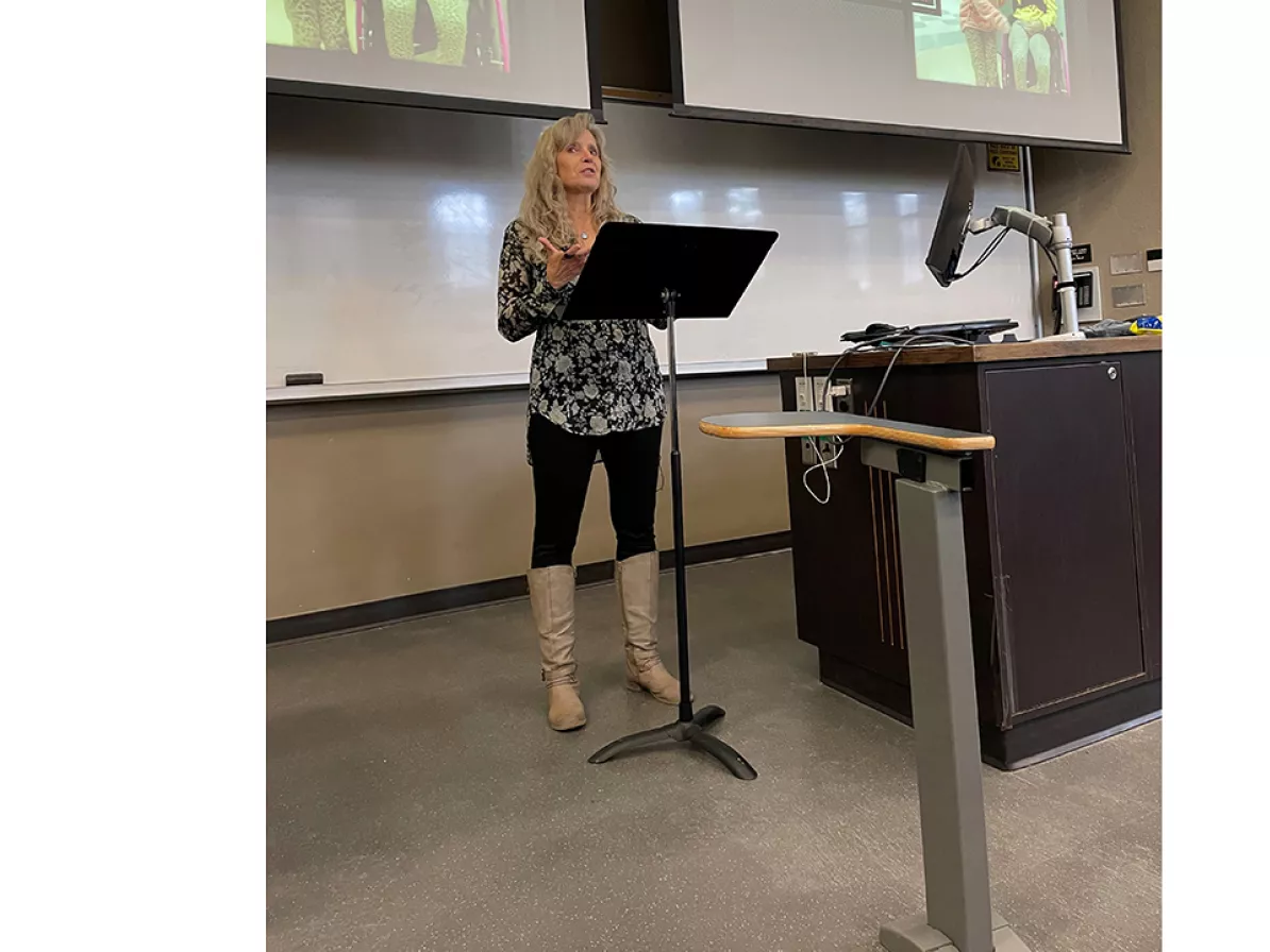 A woman speaking in front of a classroom