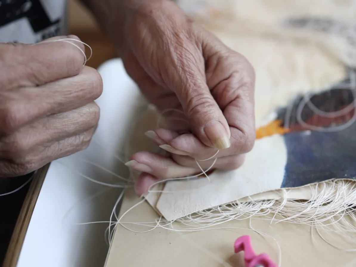 Artist Val Vint's mature hands manipulate natural materials.