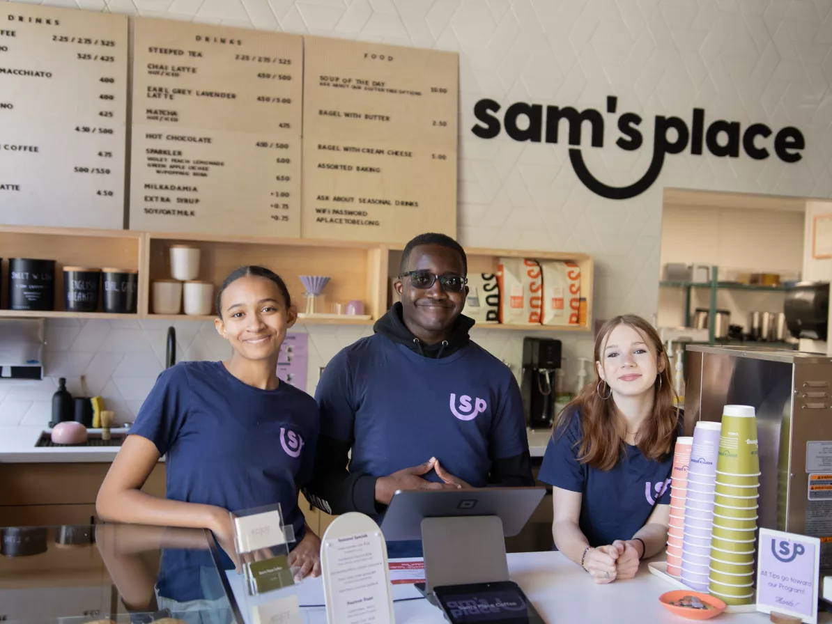 youth behind the counter at sam's place coffee smiling