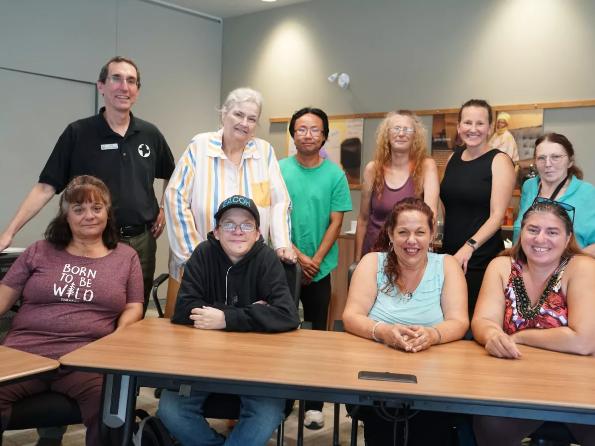 10 people sit and stand in two rows for a group photo