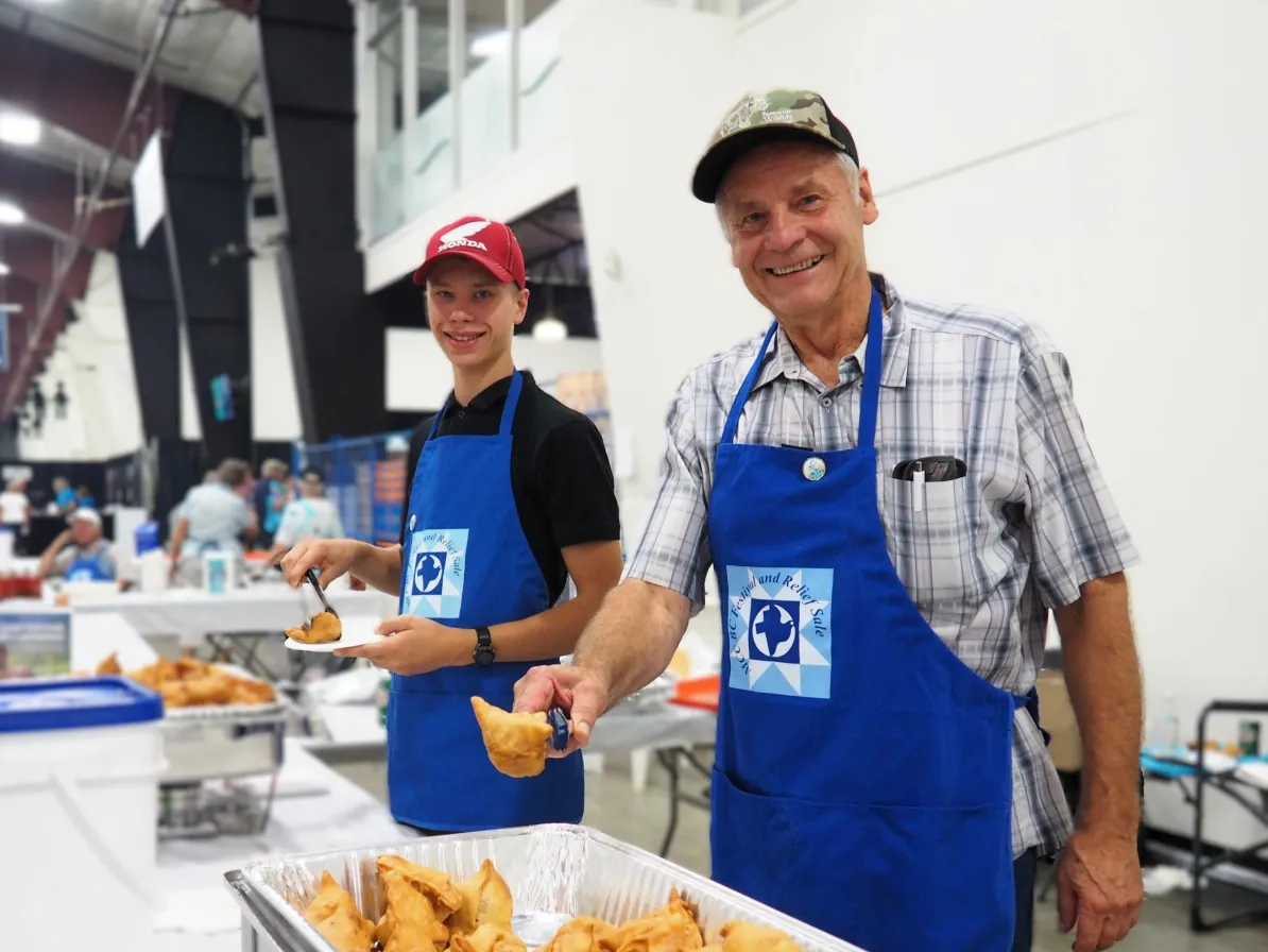 A grandfather and grandson serving food at the MCC Festival for World Relief in Abbotsford, BC