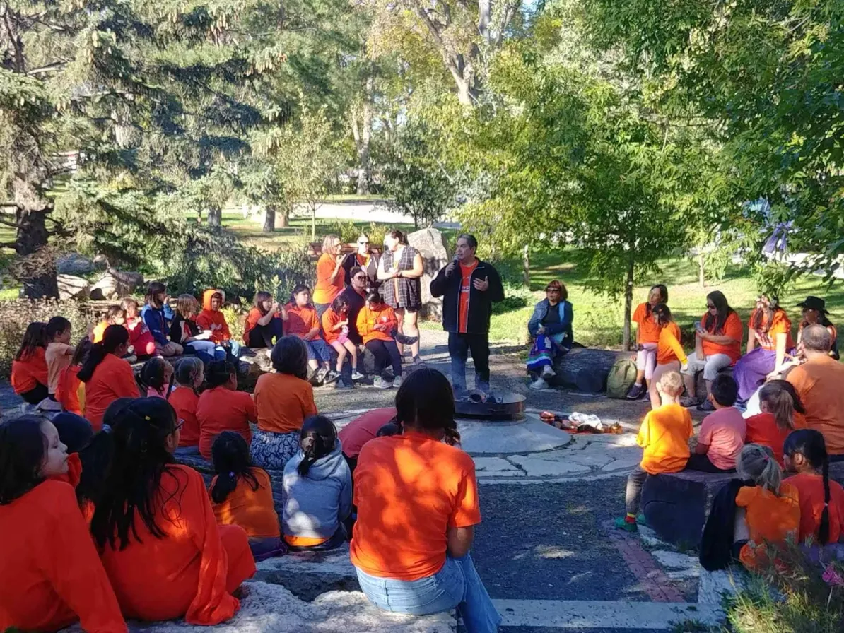 A gathering of people wearing orange shirts at the Kapabamayak Achaak Healing Forest