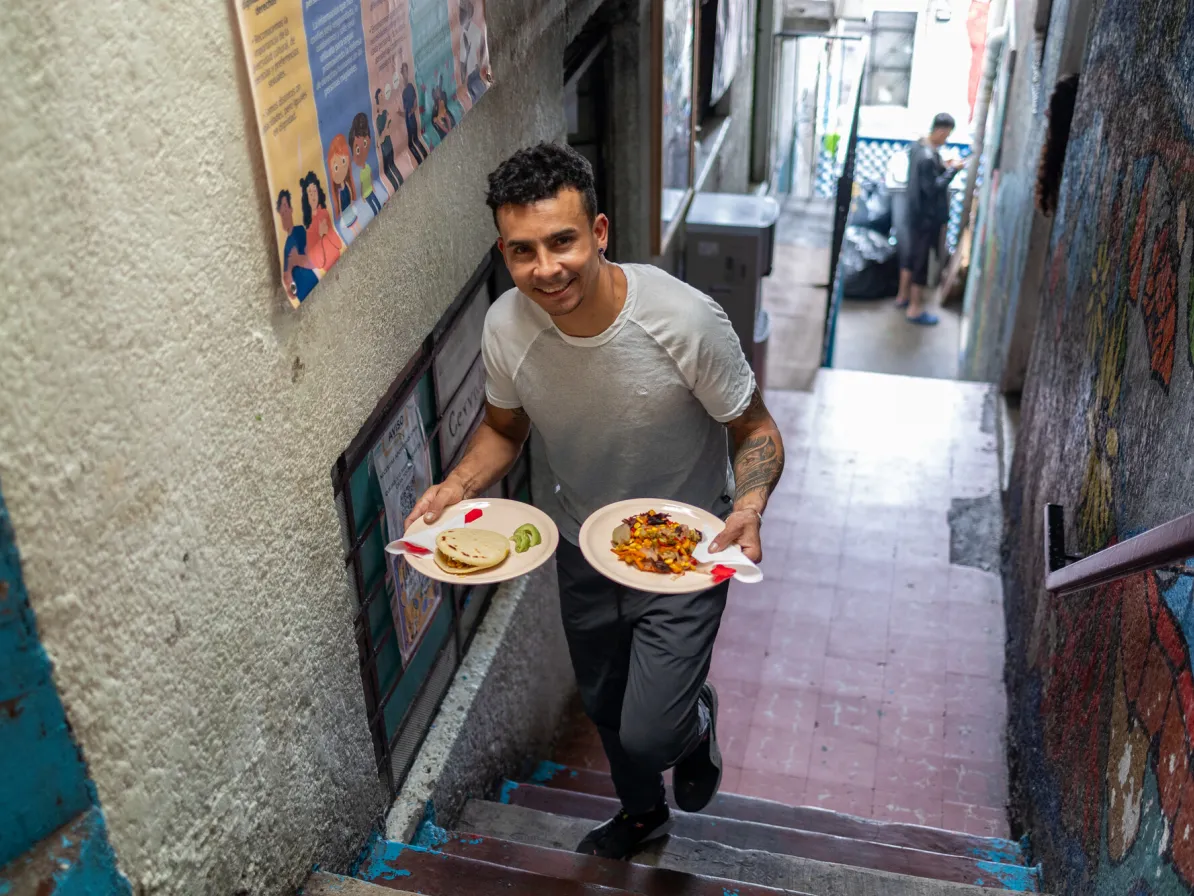 Juan Carlos De La Espriella Argel serves arepas at Casa Tochan, a shelter in Mexico City that provides psychosocial care, legal support, relief and shelter to male migrants journeying through Mexico C