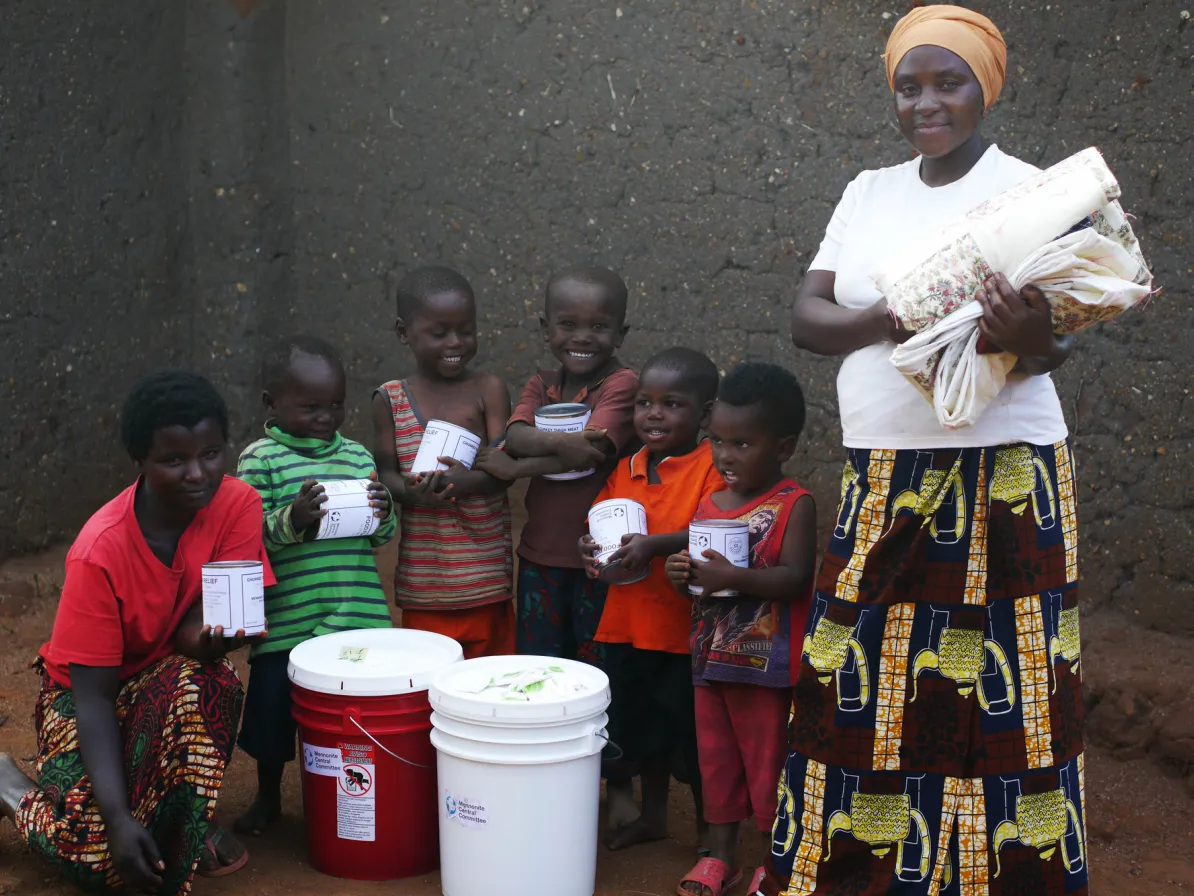 Nizigama Bestide, who lives in Dzaleka Refugee Camp in Malawi, stands with her children Ngurunziza Neema, Venist Neema, Press Neema, Gard Neema, Erie Neema, and Kabura Oneszima. 
The family is holdin