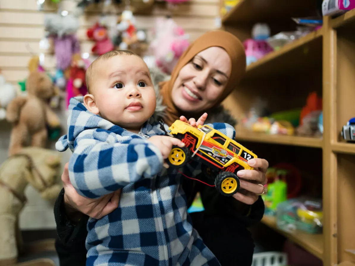 Mother Bilel Hidri and baby Byram Melliti check out the toy department at the Lethbridge MCC Thrift Shop.