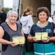 Two ladies holding canned meat
