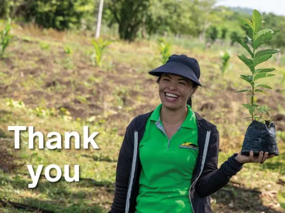 A woman holding a sapling with the word "Thank you"