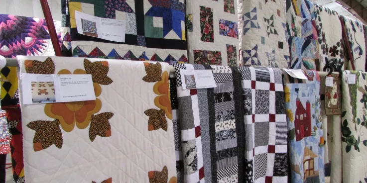 Several quilts on display at an auction