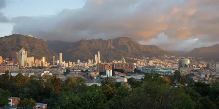 Overlooking a city skyline. Behind the buildings are mountains.