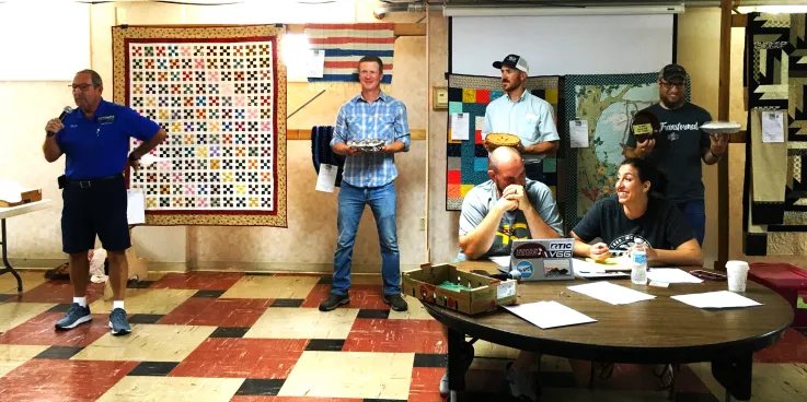 Men holding pies they made to be auctioned.