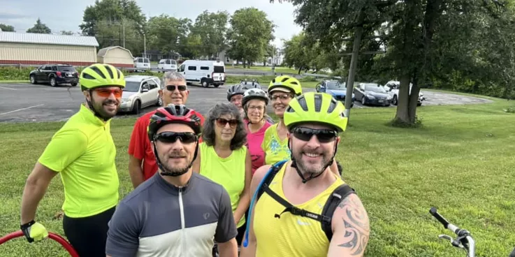 group of bicycle riders smile at camera