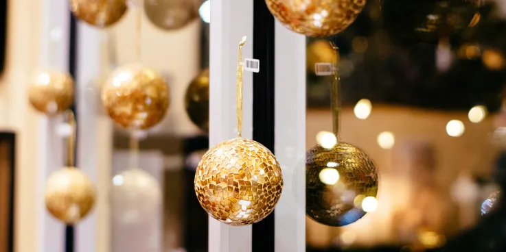 Golden Christmas ornaments hanging on a window