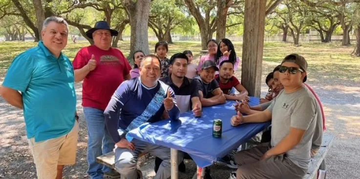 Group of people sit around a table. 