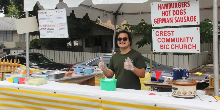 a male standing in front of a food stand