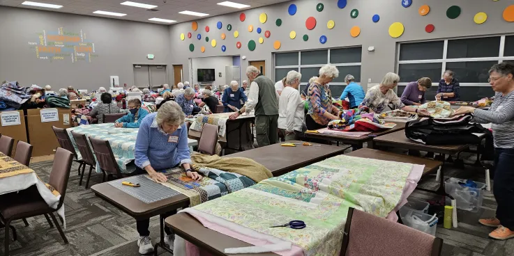 A group of people make comforter blankets.