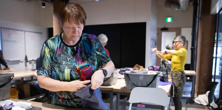 Two women pack dignity kits at a packing event in Manitoba