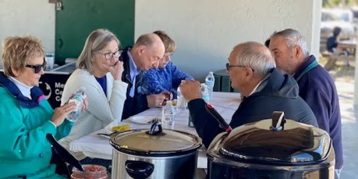 People gathered around a table, eating together. 