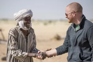 Mr. Ngueni (uses one name) shakes hands with Jonathan Austin, MCC representative for Chad, during a MCC staff visit to the North Kanem region of Chad in 2015.