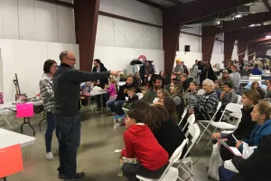 auctioneer pointing to crowd of children at toy auction