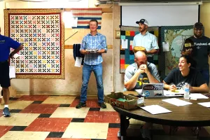 Men holding pies they made to be auctioned.