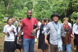 MCC Cambodia staff and students from a local school carry saplings to plant in a deforested area in the Monks Community Forest in northwest Cambodia.